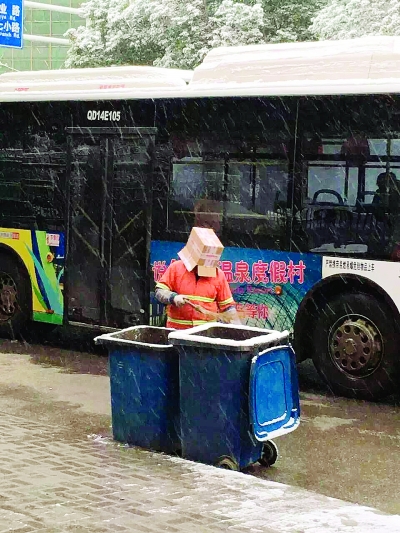 環(huán)衛(wèi)工頭戴紙盒清理垃圾桶。圖片來源于網(wǎng)絡(luò)